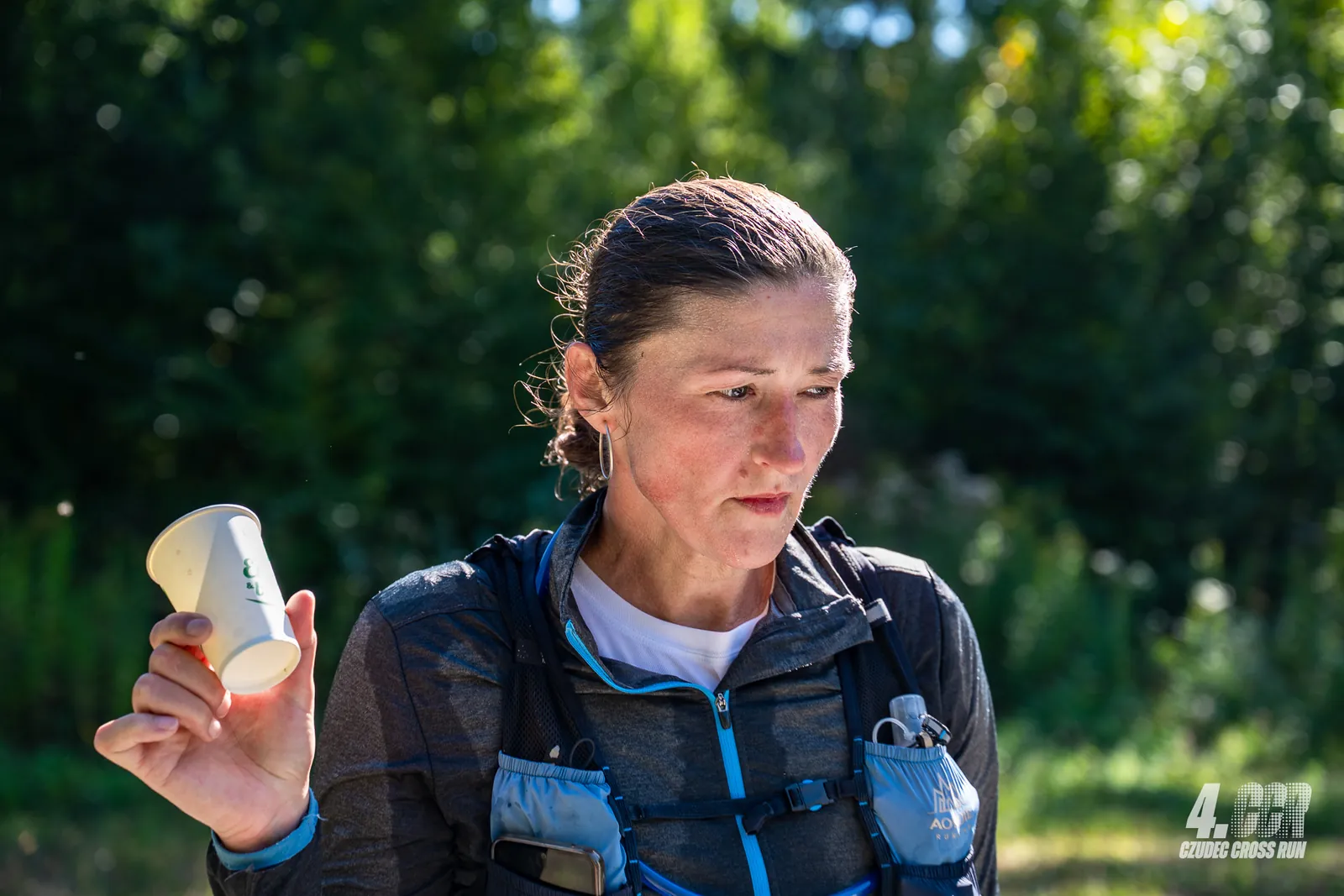 Zawodniczka Czudec Cross Run z kubkiem wody na punkcie odżywczym
